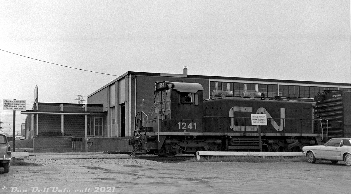 CN SW1200RS 1241 works the GECO Branch in industrial Scarborough, passing by Crown Zellerbach and their siding (T420) on the east side of Sinnott Road, just south of Comstock Road. The unit is on the Canadian SKF Lead (track T430) that ran north along Sinnot Road, with sidings and spurs branching off to serve Canadian SKF (at the very north end, closed 1981 and now a ScotiaBank call centre), the T.Eaton Company (Eaton's warehouse), Alcan Building Materials, Crown Zellerbach Bulding Materials, and Home/Acron Lumber. This lead is removed now (and the Crown Zellerbach building is today home to a pharmaceutical company), but Home Lumber to the south still recieves cars and is one of the few remaining rail customers on the GECO Branch today.Original photographer unknown, Dan Dell'Unto collection negative (large-format scanned with a DSLR, with some restoration work done).
