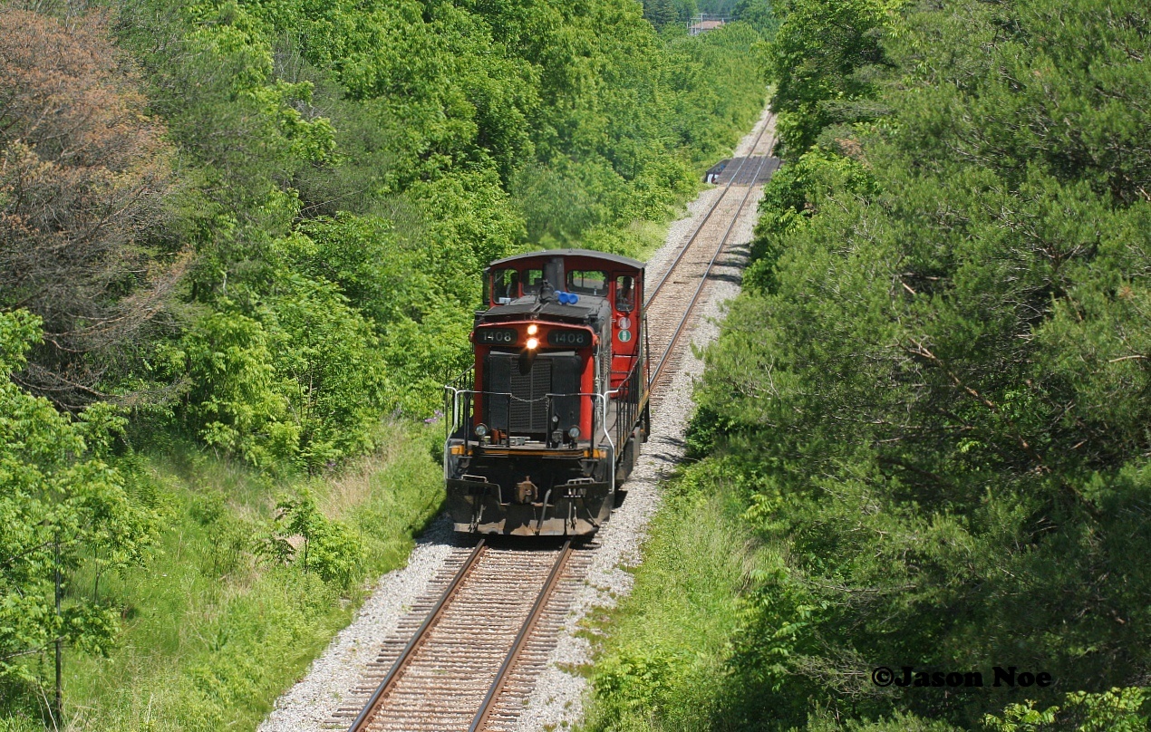 On June 16, 2020 a light work day for the crew of CN L568 required the use of only a solo unit west from Kitchener. Having been set-off by CN L533 the night prior, CN GMD1u 1408 departed Kitchener for Stratford light power and eventually headed west to London to work HCL. Pictured here L568 has just crossed the Nith River and is approaching the Perth Street bridge, just west of the town of New Hamburg. 

Less than a year later on March 10, CN had retired a large portion of the 1,200 horsepower GMD1’s that were still on the active roster, including units; 1408, 1412, 1437, 1440 and 1444. These units had been placed in storage out of service at CN’s MacMillan Yard in Toronto during the past winter.
