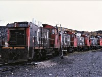 Four of CN's five 1500s take a breather at Sudbury, Ontario.  Almost consecutively numbered, 1504 1505 1507 1506, are pictured.  Missing is the 1508. The locomotives are on the west leg of the "Y" at the shop area. The 1500s weighted in at 246,000 pounds while most of the other SW100RS units tipped the scales at 222/223,000 pounds.  The extra weight of these units came in useful handling all the ore and sand traffic that Sudbury once handled.  Nothing in this scene remains.  