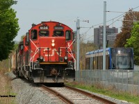 CN L568 with 4136 slowly shoves toward downtown Kitchener on the Huron Park Spur as an ION light rail movement heads the opposite direction approaching Mill Station at Ottawa Street.
