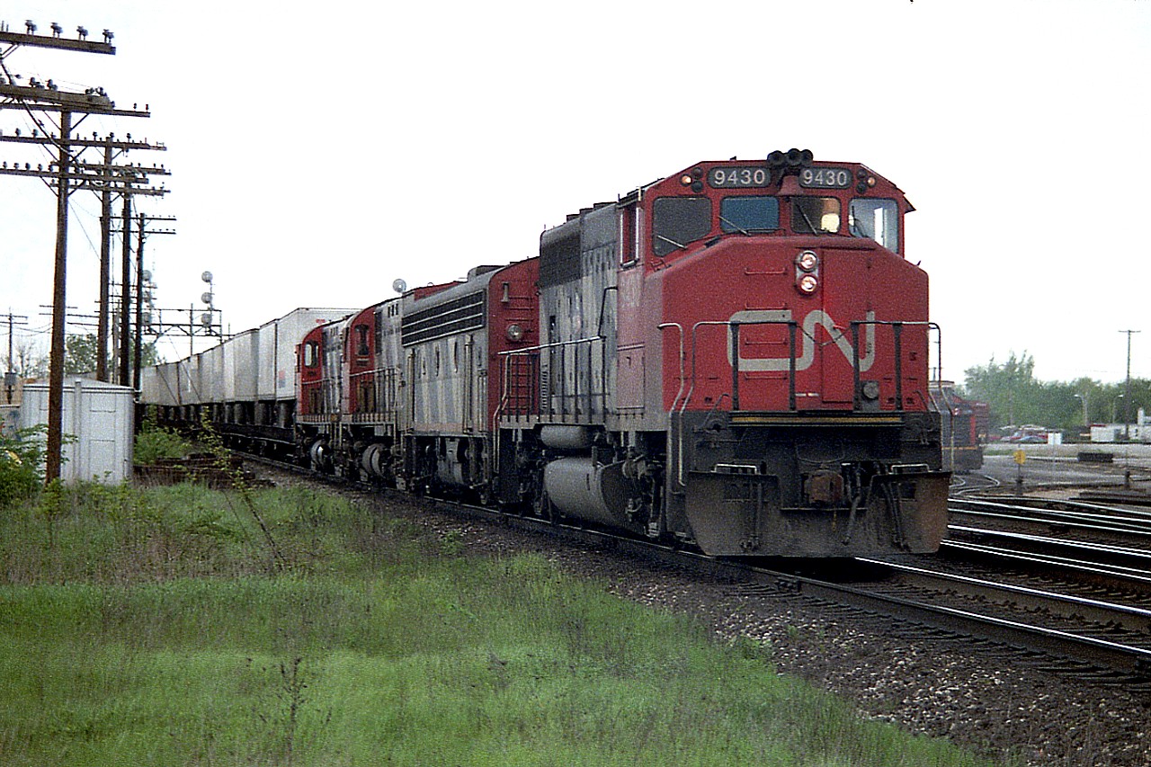 On another one of those days in which the sun was successful at avoiding me; a visit to the old Freeman Station in Burlington resulted in catching a westbound off the Halton waiting for a light. Probably the Oakville Sub was busy with passenger traffic.  This train, with a string of TOFC, was powered by CN 9430, B unit 9195 and a couple of C-424s, 3213 and 3208.