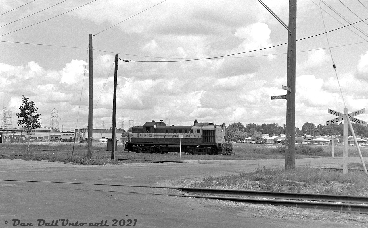 Sitting in suburban Scarborough at the border between industrial areas and residential neighbourhoods, Canadian Pacific RS3 8445 awaits its next duties switching the Scarborough Industrial Spur, on one of the leads near the Ashtonbee Team Tracks at Bertrand Avenue and Thermos Road. The single-level suburban houses visible in the background are located off Birchmount Road, and the large factory in the background is the Federated Metals plant.The Scarborough Industrial Spur was built in the early 1950's to serve the industrial post-war boom in the "Golden Mile" area of Scarborough, one of the fast-growing inner suburbs surrounding the old city of Toronto proper. It branched off CP's Belleville Sub at Mile 201.36, crossed Warden, and ran south parallel to Warden and Birchmount (serving a few businesses that sprung up along Howden Rd enroute) to reach industries in the Golden Mile north of Eglinton Avenue East, which included Volkswagen of Canada, Link-Belt, Canadian General Thermos, Kaiser Aluminum, and Canadian General Electric's Scarborough plant (formerly English Electric / Inglis). There was also a branch that ran up Underwriters Road, and a few sidings and ramp for a team track at Ashtonee Road (see 1957 CofT aerials here and here). The Golden Mile industries on the south side of Eglinton were served by CN via their "GECO branch".  CP's Scarborough Industrial Spur was eventually abandoned in the mid-90's as all the old heavy manufacturing industry left the area or switched from rail to truck, and urban redevelopment and gentrification of the area started to set in (the Golden Mile strip of Eglinton today features power centers, car dealerships and big box plazas mixed in with repurposed industrial buildings and some remaining legacy industry, and the Eglinton Crosstown LRT line will bring more changes when completed in the future).Original photographer unknown, Dan Dell'Unto collection negative (large-format scanned with a DSLR, with some restoration work done).