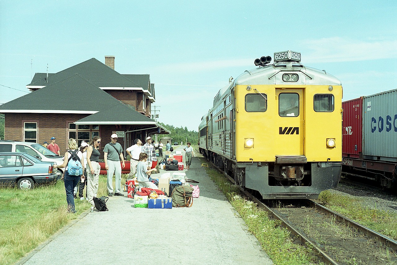 One of the scenes that has so embedded itself in my mind when I think of the North is that of the VIA Budds stopping at Cartier. It seems that there is always a gang waiting for this little train. Once you sort it all out, perhaps there are not all that many riders, and there is a heck of a lot of baggage..but still...it is a jovial atmosphere amongst the locals and is a nice break between the parade of freight trains with, outside of crew changes, their impersonal passing. This image is of a typical day, although not as busy as I have often witnessed it.

Units are VIA 6205, 6250.....destination White River.