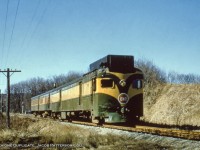 Seen in it's original paint scheme (post 1951-52 rebuild <a href=http://www.trainweb.org/oldtimetrains/photos/cnr_self-propelled/15834.jpg>from CNR 15834</a>), CNR D-1 and trailers C-1, C-2 roll along the Milton Sub near Burlington, likely having just crossed old Highway 25 (note wig wags and traffic in the distance).  Within the year, D-1 would receive a new paint job as seen in <a href=http://www.railpictures.ca/?attachment_id=45490>this 1958 photo,</a> as well as an additional window at the centre of the cab, and new headlights.  Note the early version of the CNR maple leaf logo.  Images of this scheme an logo can be found back to 1948, though the year of introduction remains unknown.  Anyone?<br><br>This location proved a challenge to find, as the slide was simply marked "near Hamilton."  After looking over <a href=https://mdl.library.utoronto.ca/collections/air-photos/1954-air-photos-southern-ontario/index>1954 air photo of Southern Ontario,</a> and comparing this to google maps, sun angles, and with a <a href=https://railwaypages.com/timetables>1956 timetable</a> I believe the location to be along the Milton Sub (single track) and between the curve near the Guelph Line crossing and the curve at Walkers Line.  The 1954 aerial shows little foliage around the crossing though, which leaves one location, a crossing, now long gone, just east of Guelph Line that would be located roughly where the Burlington Leon's is located.  The 1954 aerial labels it as Highway 25, though today that would be farther east from here, presumably relocated/renumbered over time.  The return trip at this location would be under the cover of darkness, making this the morning trip, train 660 to Georgetown.  Further train numbering information under 1958 photo linked above.<br><br>More <a href=http://www.railpictures.ca/?attachment_id=13904>CNR green and GOLD,</a> 1952 by Bill Thomson at Toronto.<br><br><i>Original Photographer Unknown, Al Chione Duplicate, Jacob Patterson Collection.  Geotagged location not exact.</i>
