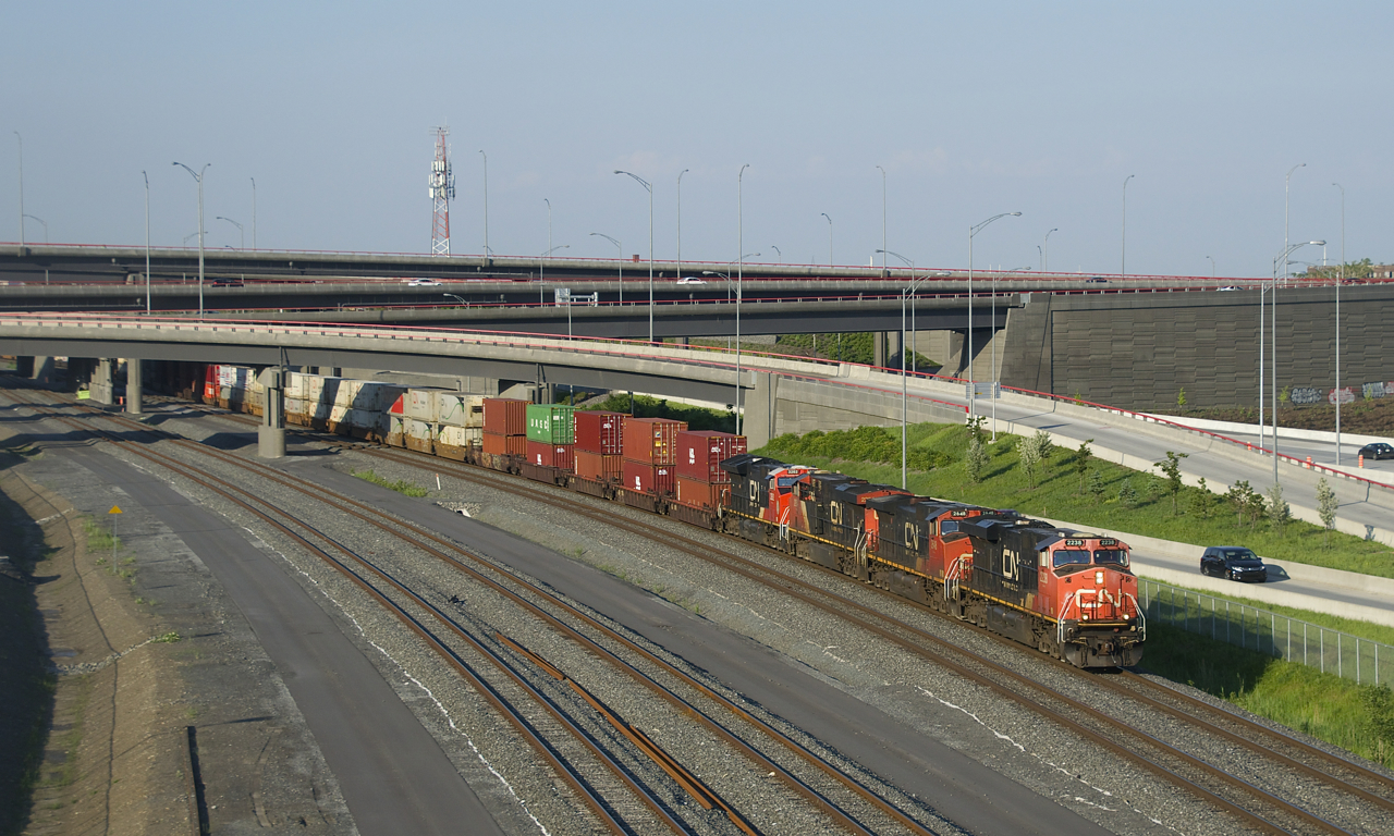 A 618-axle long CN 121 is emerging from the Turcot interchange on a scorching evening. Power is CN 2238, CN 2648, CN 2254 and CN 3262 up front and CN 2288 mid-train.