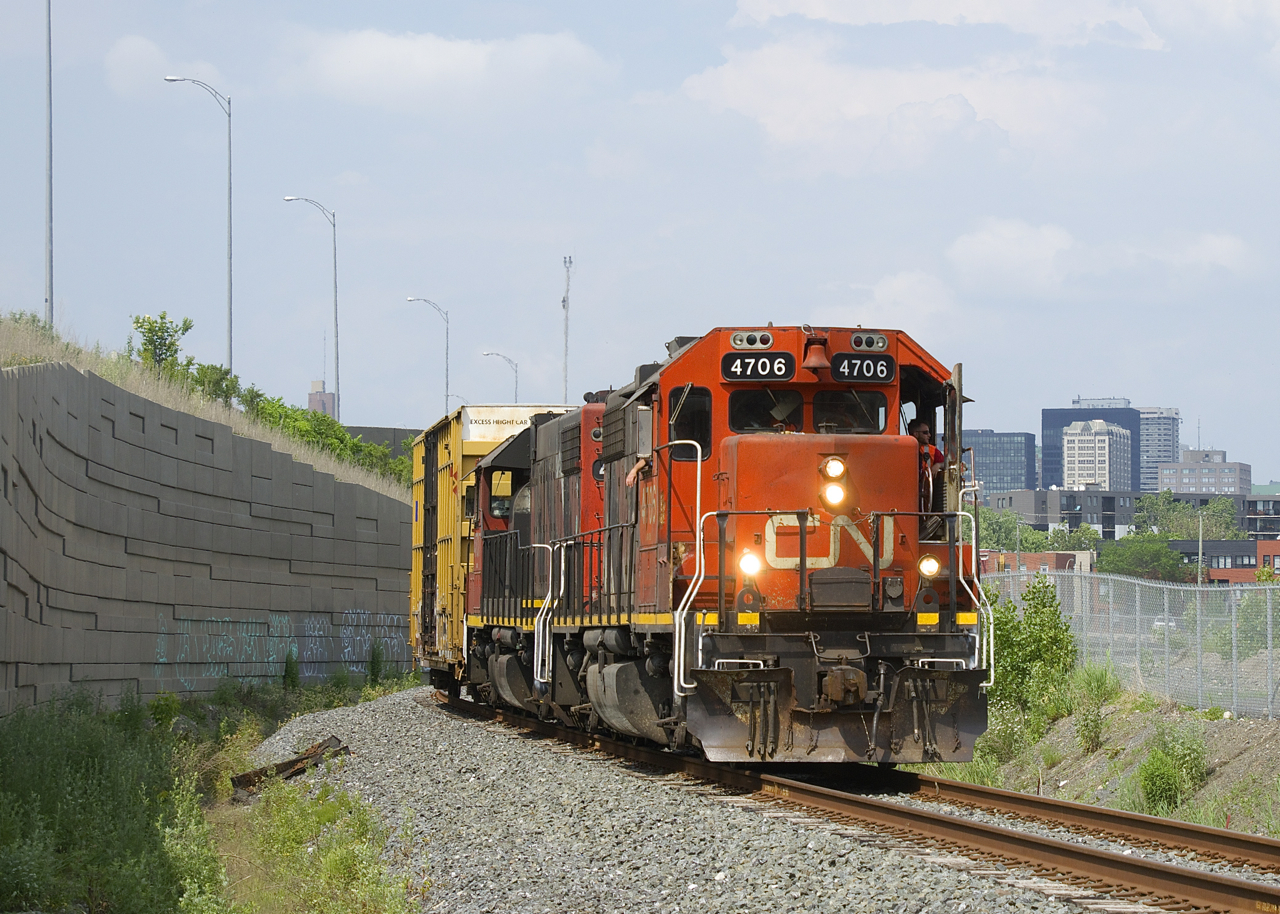 The Pointe St-Charles Switcher is heading to the Kruger plant with a single boxcar and CN 4706 & CN 4707 for power as they approach a level crossing at Notre-Dame Street.
