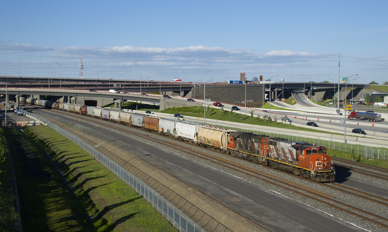 CN 596 has a long transfer from the Port of Montreal as it heads towards Taschereau yard with faded zebra striped CN 4774 & CN 4706 for power on a lovely spring evening.