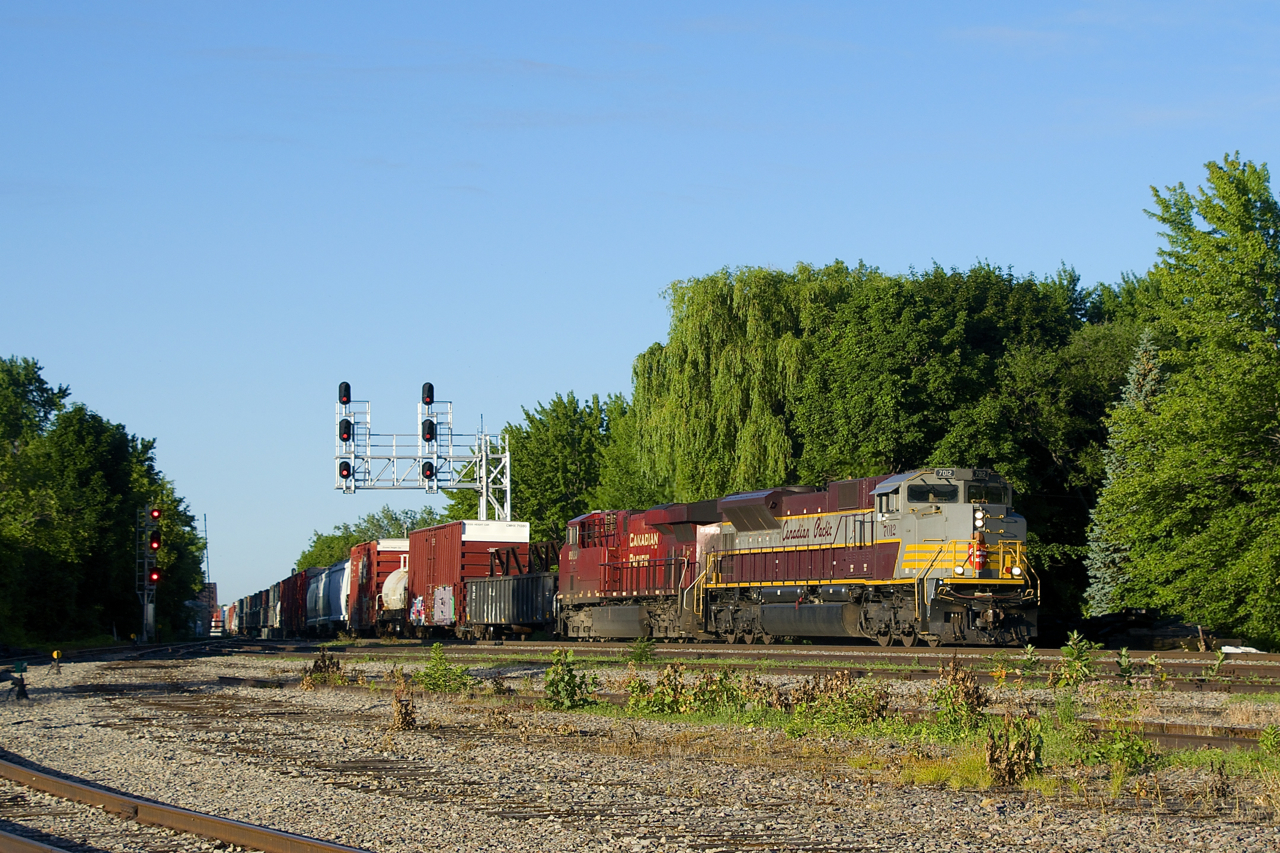 It's early in the morning as heritage unit CP 7012 (along with CP 8923) powers a short CP 253 off the St. Lawrence River bridge and past the partly torn up Lasalle Yard.