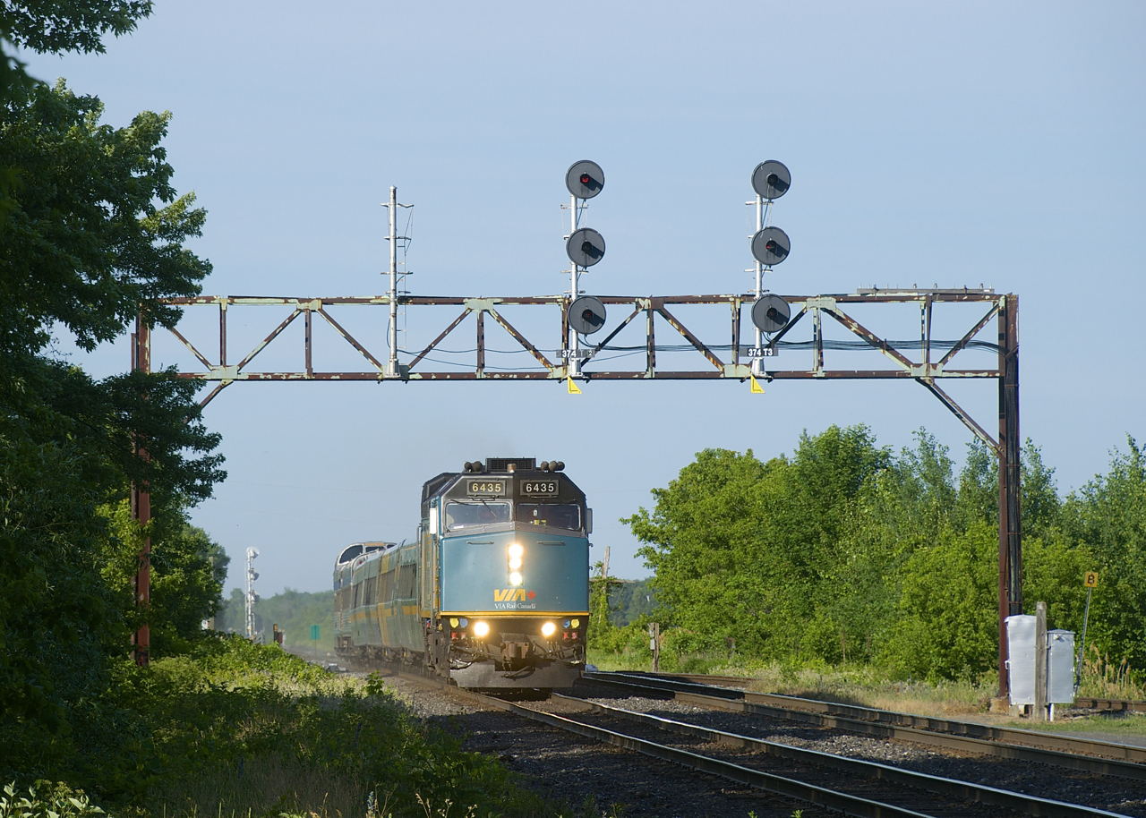 Park car Banff Park is on the rear of VIA 69 as it passes underneath a vintage and endangered signal gantry in Coteau.