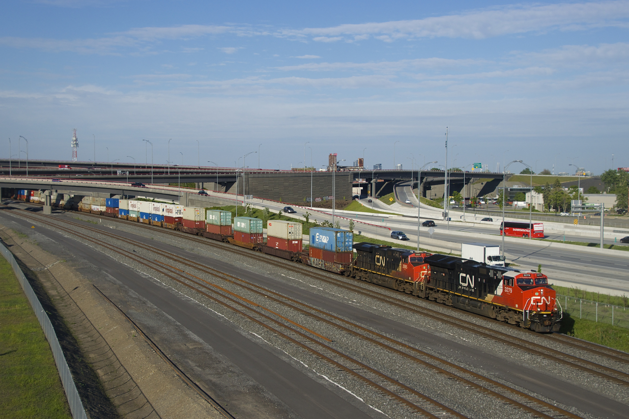Clean CN 3279 and much dirtier CN 2885 are on the head end of CN 121 as it passes the recently rebuilt Turcot interchange. Mid-train is CN 3164.