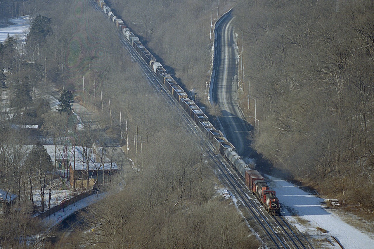 Good Grief!!!  A GMD-1 powering an eastbound??  Sure looks like it; but of course we know that is not the case. It is just another day on the Copetown Hill, as westbound CN #385 has gone thru it's usual "stall" and the word goes out to Aldershot to send somebody up to push. On this day, it happened to be GMD-1 1444 and GP38-2 4700 available to do the honours.  Made for an interesting photo op, thats for sure.
I was unable to view the power on #385 as the train had been dead on the hill for close to an hour by the time I got to Dundas Peak.