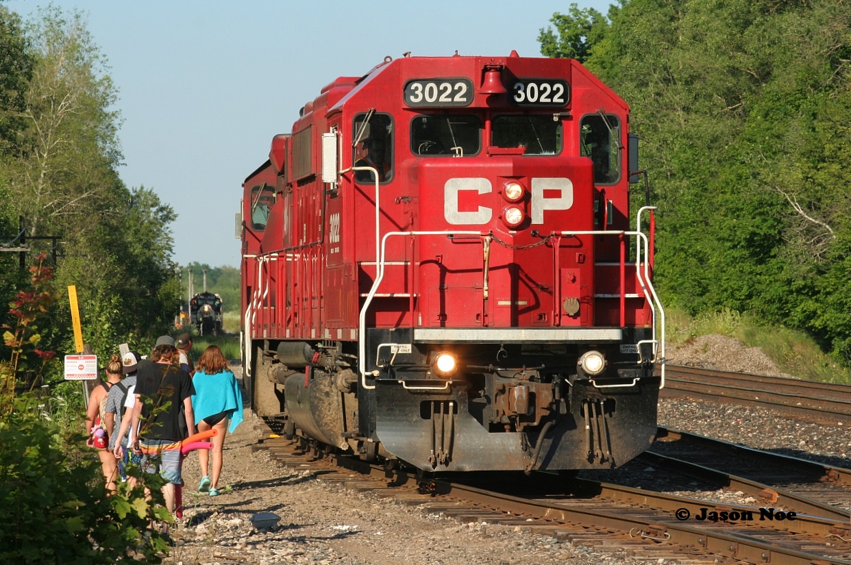 Back in the day many years ago you would see the odd person with a fishing pole or a cooler heading towards the quarry near the west end of Guelph Jct. Last summer while photographing OSR coming back from Guelph I remember pulling-up to the crossing and thinking to myself, there were certainly a lot of railfan’s wanting to shoot this as well. I couldn't have been more wrong as it turned out all the cars parked along the road where either people heading to the quarry or returning. There wasn’t another railfan around. For almost an hour I watched as the seemingly endless parade of folks either walked along the ROW with coolers, beach gear and eventually even ATV’s heading to the popular quarry or back to their vehicles. Man how times have changed. 

Here CP T69 builds its train to head back west with 3022, while OSR completes its last moves of the day in the background while the steady stream of people continue their way to the nearby quarry during a humid summer evening.