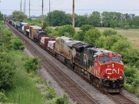 One of CN's new arrivals in the form of a former CREX/Citi Rail ES44AC, now CN 3914, trails CN 3166 as the pair along with another Gevo deep in DPU mode haul a long train 385 under Guelph Line in Burlington on a very humid June day. 
