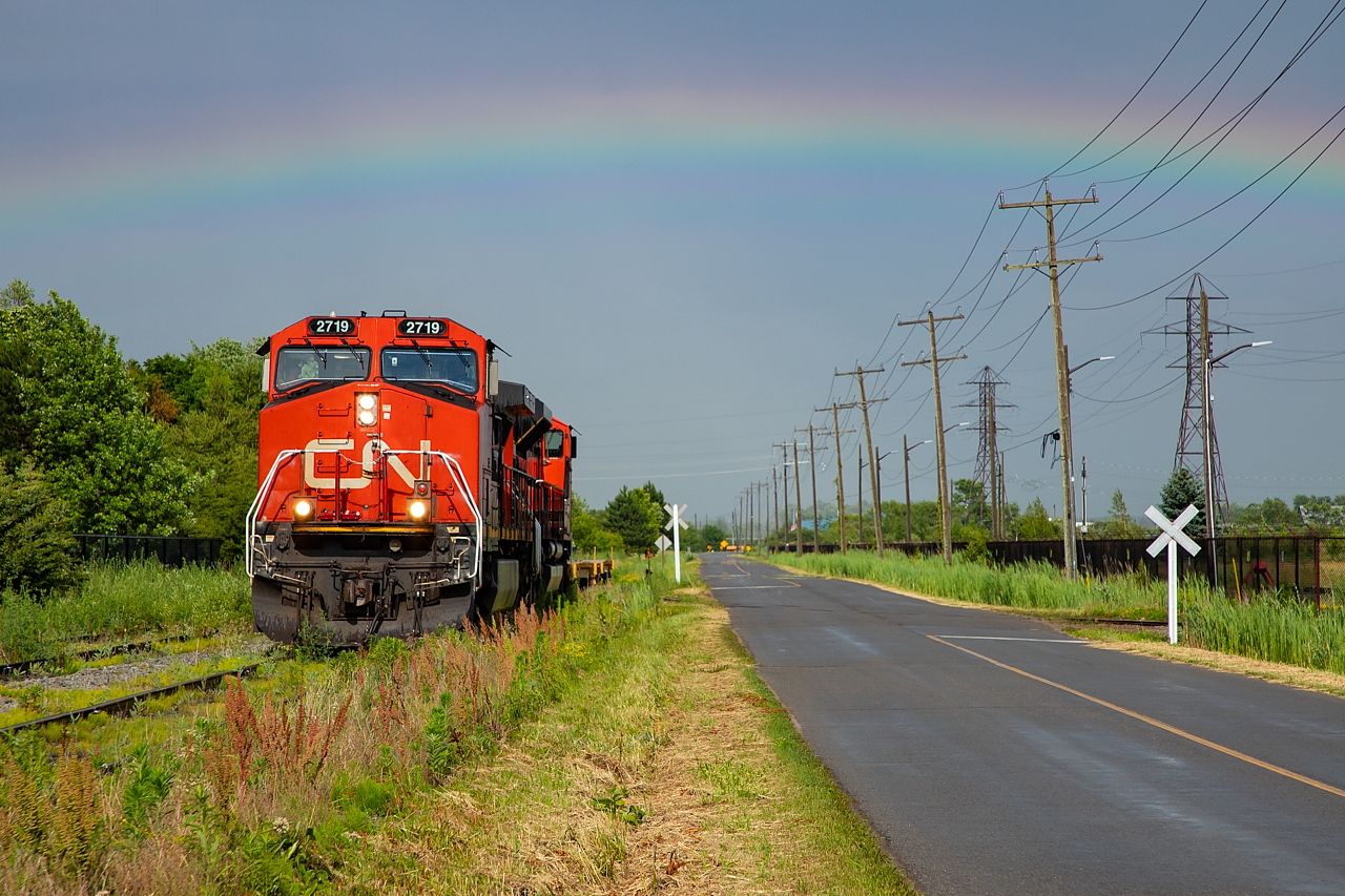 A little over a couple of weeks after seeing 562 spot two transformer loads in Port Colborne for the nearby hydro substation, I happened upon them lifting the two empty flats. After a brief and intense downpour, we were treated to some bright sun and a rainbow to boot.