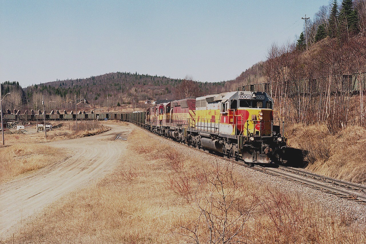 WC 6001, 6590, 2252 and 2052 pulls away from the harbour facilities (on Lake Superior) with ore loads for the steel company in Sault Ste. Marie. This image was taken shortly before the operation shut down for good. Tracks for the sub were then pulled up in 2000.  Michipicoten Harbour then slid back into being somewhat of a ghost town compared to its past heydays of 25 homes, a store, a school and so on...........now, just a few homes and cottages. Superior Aggregates I understand is opening up a trap rock mine in the area, so the community may very well be reborn once again. Lead unit 6001 renumbered for new owner Wisconsin Central, but is still in Algoma colours.