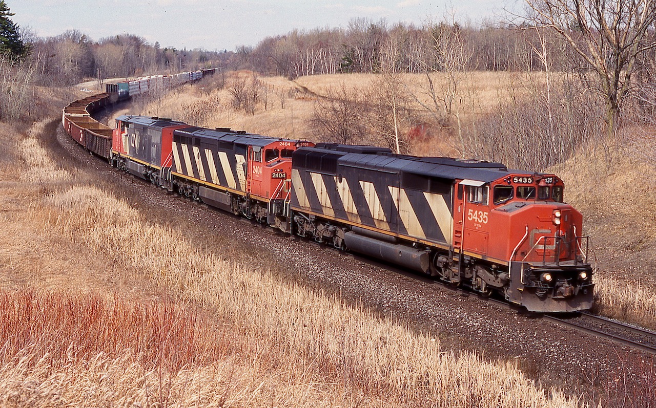 This was certainly a place I could never get sick of back in the day. Before the big golf course was built here, this location was surrounded by rolling farmland. The ten minute hike up the hill was always worth it and a lot of friendships were built around mile 30. I always loved the Draper years on CN and this day presented me with one of my favourite shots from this location. Trains 334/335 were always interesting and often had NS power out of Buffalo on it. Unfortunately the Niagara region traffic gradually dried up as it was rerouted, much of it was relocated to and from Montreal instead of Toronto. This day three cowls in the form of a SD50 and 2 Dash-8's are in charge of train 335 as it rolls through the dormant landscape at mile 30.