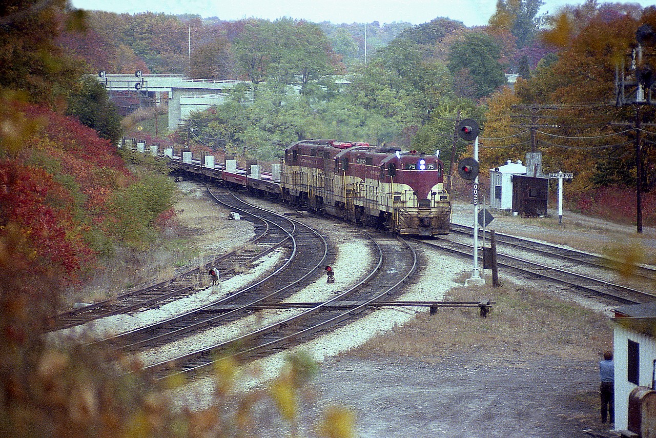 A nice, but overcast fall afternoon (all afternoons were nice when the TH&B was sighted) sees the TH&B starlight Hamilton-bound with TH&B 75, 402 and 76 providing the power. String of empties for TOFC up front. Old time scene shows steam-era (later MoW) helper track still in place; new walkbridge devoid of rail buffs; the old 'Bayview' sign is still the wooden version.......no idea who the photographer is down by the shed.
