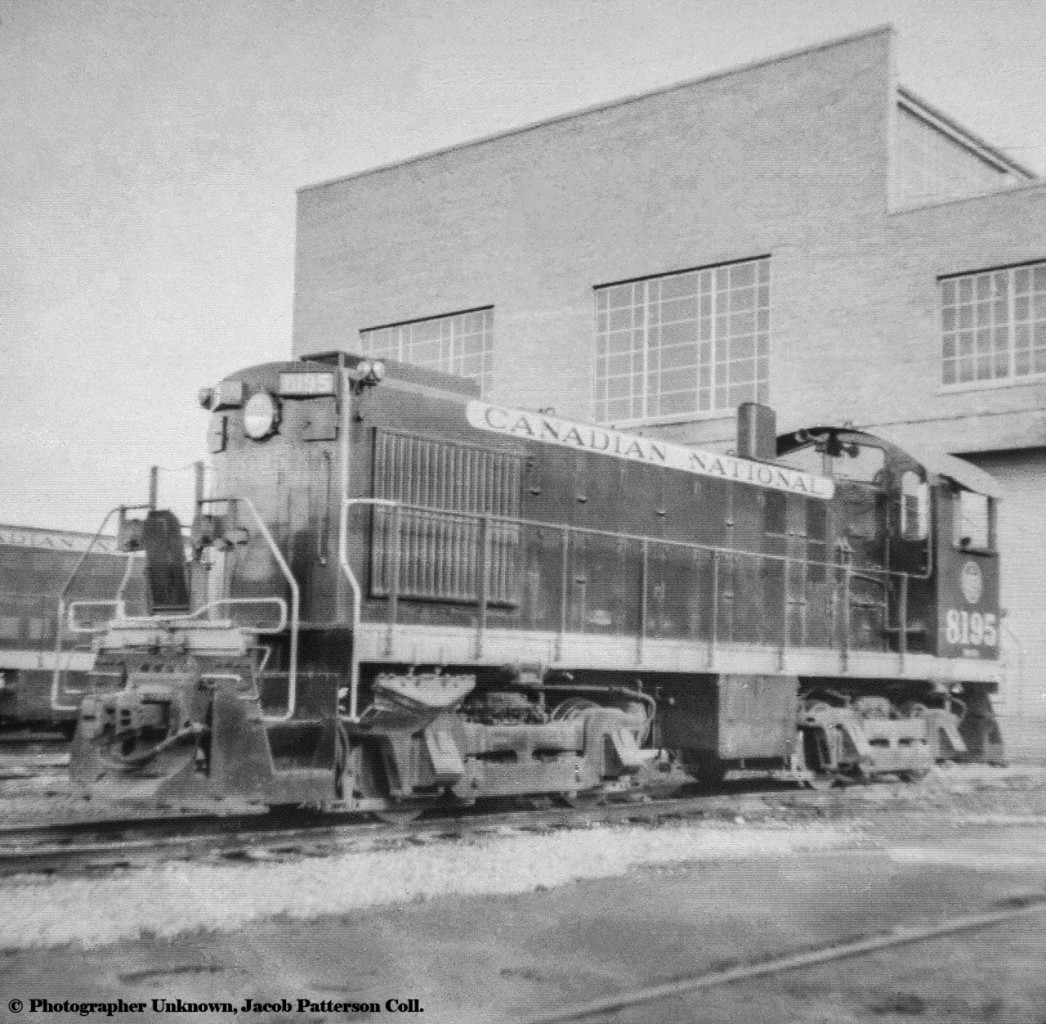 Canadian National Railway MLW S4 8195, built 1957, is seen on the west end of the old Vancouver diesel shop, now home of the Rocky Mountaineer station.  Another switcher is seen in the background, and like 8195, it is in the early black and yellow switcher scheme.  All CN S4s would be retired by 1985.*Scanned from 2 1/4" x 2 1/4" slide with a DSLR.Original Photographer Unknown, Jacob Patterson Collection Slide.