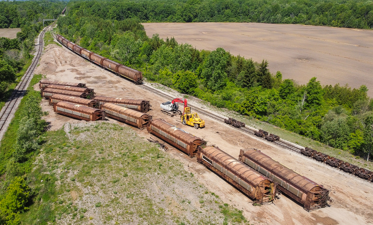 While in the Niagara area yesterday I came across a sad yet interesting scene.  10 ex Canada Wheat Board hoppers lying on their sides awaiting the scrappers torch while a string of 9 more wait nearby.  There is also another large cut off in the distance.  These cars were built in 1979/1980 and with CN and CP taking delivery of new hoppers over the last few years these grain cars were on borrowed time.  It is sad to see them go.