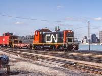 It's March 29, 1983 in Windsor, Ontario where CN 7220 and its short train have the Detroit skyline in the background.