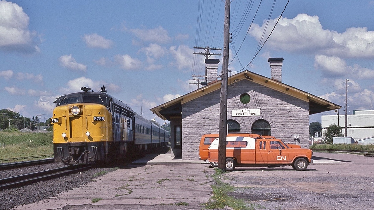 VIA #43, The Lakeshore, rolls by the restored ex GTR built station


   When CN announced a proposed closure and removal, the Town Council rallied the community stakeholders including the Ontario Heritage Foundation, VIA, CN, etc to restore the station to the original 1881 appearance    


   Hence with CN contributing to the restoration the building remained labeled 'CN Port Hope' for some time after the 1985 restoration.


   at  CN Port Hope, July 20, 1986 Kodachrome  by S.Danko 


   Circa 1986 five VIA trains – two west, three east -  served Port Hope: 

   daily Budd Car commuter trains #651 (ex Sun) & #652  (ex Sat) 'Ontarian' ;
  
   Daily #68 'Bonaventure' ; 

   and daily overnight  #58 & #59 'Cavalier'...a very long day trip to Union: a 05:58 departure and a 01:01 arrival.


   Noteworthy


   In normal times, Port Hope a busy commuter place,  with daily trains: 651, Saturday 655, 54, 48 and Sunday 648
   

   Circa 2021 served by trains 42, 643 and 55.


   the Cameco spur on the right sees regular use


    in the weeds