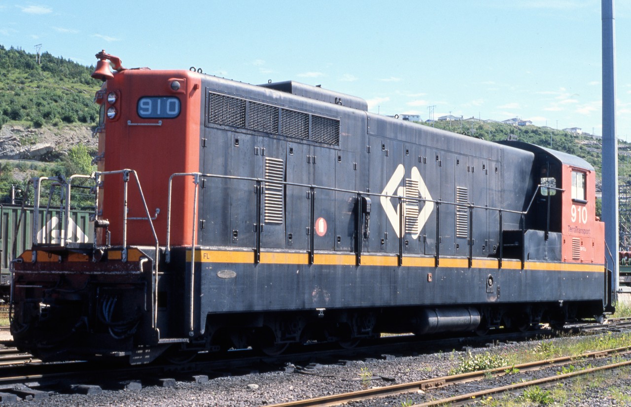 NARROW GAUGE NEWFOUNDLANDER. On the warm summer afternoon of August 7, 1988 Terra Transport NF210 # 910 waits in the St. John's Yard for her next assignment. This particular unit, was the second one of 26 (909-934) built by GMD of London, ON in 1956 and delivered to forever banish the 2-8-2 Mikados and 4-6-2 Pacifics then operating on the narrow gauge railway. With a CN class of GR-12g, this 1200 hp roadswitcher had C-C 3'6" flexicoil trucks and a top speed of 60 mph. Originally delivered in the CNR's handsome green and gold paint scheme, it was repainted in the 1960's black and red noodle, and finally the 1980's Terra Transport bi-directional arrow. With only seven weeks until the last train, the 910's assignments would be limited but will still traverse the 547 mile mainline. Fortunately this unit would survive the September 30th abandonment and be sold to FCAB and continued operating as their # 1416.