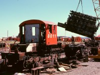 The Baldwin 606SC engine (sans turbo) of 8011 in the air during scrapping at Wellcox yard in Nanaimo on Tuesday 1974-07-30.  One near-comical tension relief during the scrapping was when each engine was first lifted clear.  All shopstaff “knew” there should be a treasure trove of tools lost underneath during earlier years, never to be retrieved unless the engine was removed, but nothing of significance was ever discovered there, much to the prime scavenger’s dismay!
