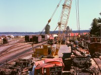 For me, the shot of E&N Baldwin scrapping at Wellcox in Nanaimo in July of 1974 that sums up the mess there is this, debris all about but operations continuing with cabooses all lined up and the yard office with scrap cars being scaled behind the crane’s boom.  In the foreground, the day and afternoon chargehands at Wellcox (a job I worked six years later) are observing.  That I was able to photograph it all from a variety of perches among the activity was due to the tolerance of Victoria locomotive foreman Hugh Albert Miller, who also organized and managed all the scrapping with no injury to any of us.  Thank you, Hughie.