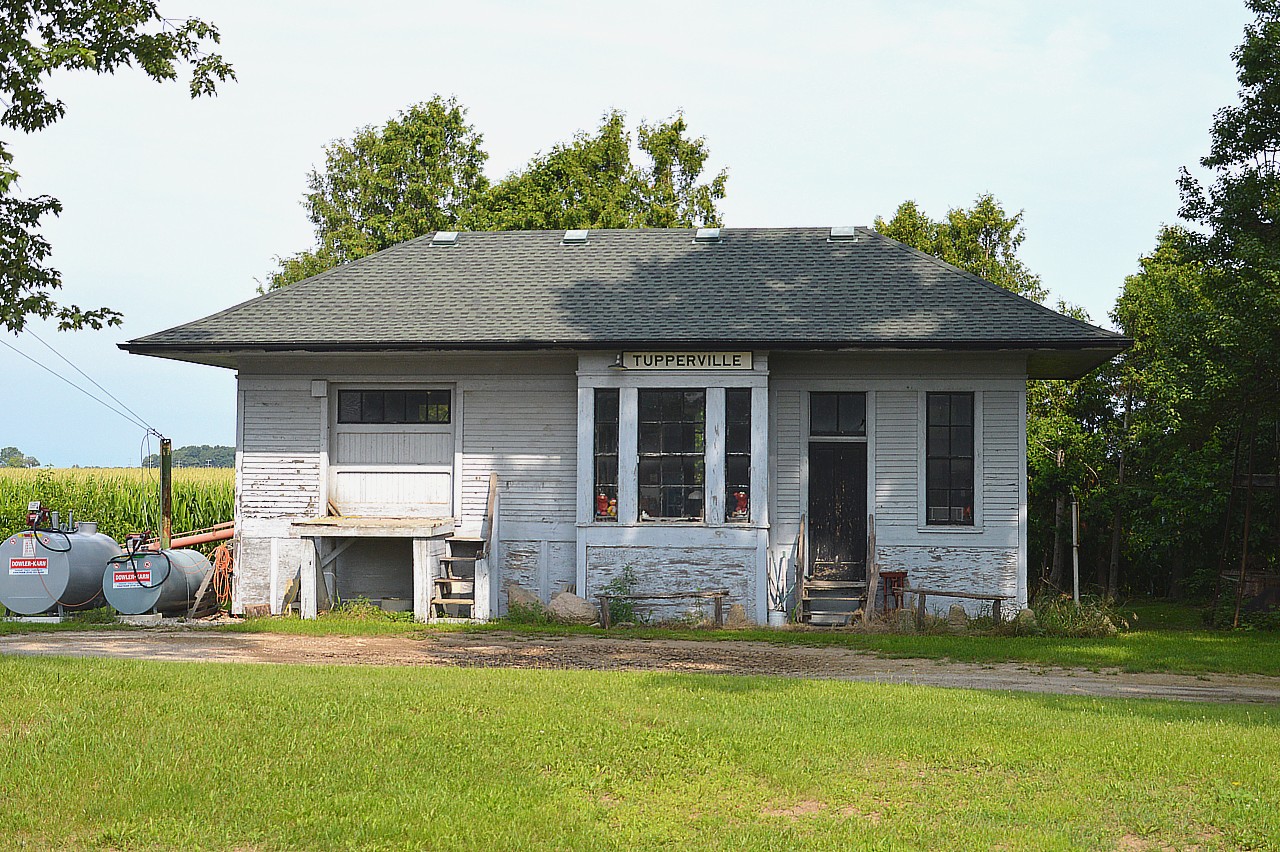 Another station for the series........this time Tupperville. The Erie & Huron in 1883 constructed a line from Lake Erie (Rond Eau)thru Chatham, Dresden, Wallaceburg and up to Sarnia. The little village of Tupperville is just south of Dresden.  I do not know how long ago the station was moved to its' present location on a local farm (family museum) nor when the line was shut down. It had been open for moving grain a few years back. Crossing signals still in place at the village. Have no date on the construction of the station, either, but I do know this was once Pere Marquette track; in 1947 became part of C&O and in 1972 part of Chessie.
Info would be appreciated.  Note there are a couple of what looks like "Elmo" dolls in the windows. :o) Tupperville was named after Sir Charles Tupper, in case anyone is curious.