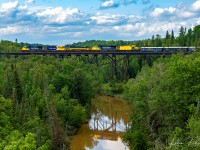 Ontario Northland Northbound 113 being led by 2102, 1735, 1730, and 2105 crosses the Englehart River bridge on final approach to Englehart.<br>
In tow, looking tiny behind 2105 is Xstrata / Glencore's GP9u 1684 on its way back from the Diesel Shops in North Bay to Kidd Creek Mine in Timmins.<br><br>
Temagami Sub - Englehart - July 29