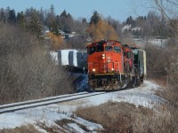 With Snyder’s Rd in the background on the outskirts of Kitchener, CN GP40-2W no. 9547 leads 568 westbound after just cresting the grade out of Kitchener with the pair of iconic Canadian engines still working hard as they curve through the country side beside the Petersburg Regional Forest Trails on a snow covered sunny afternoon.