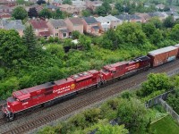 CP train 651 is dead in the water after the trailing GE died after blowing its engine. Oil can be seen all over the rear of the trailing engine and first boxcar. The location is west of Mavis drive in Cooksville. The crew was still on board.