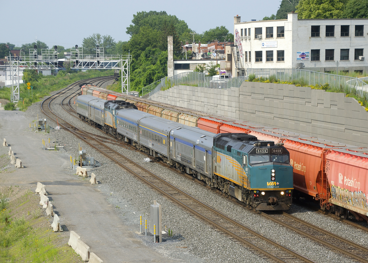 Normally arriving into Montreal late in the evening, the combined VIA Rail train from northern Quebec is now entering Montreal in the morning after a mostly nocturnal run. This is a temporary measure to avoid heat-related slow orders and took place last summer as well. Here VIA 602/606 is passing the tail end of a parked CN B730, its long run nearly done.