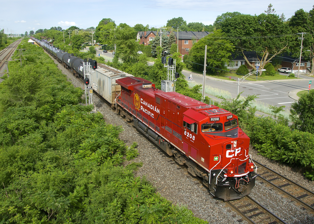 Fresh rebuild CP 8208 (ex-CP 8560) leads ethanol train CP 650 past a pair of signals in Pointe-Claire.