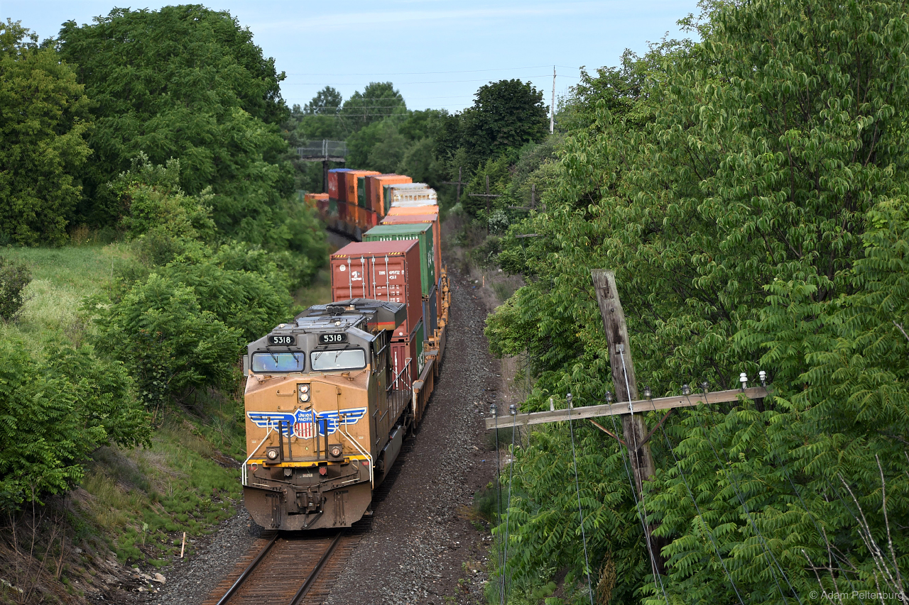 An American visitor pushes from the rear of CP 113 at dawn, rounding a sweeping curve through the southeast end of Oshawa and passing underneath the old wooden pedestrian bridge at Farewell Street in the distance.