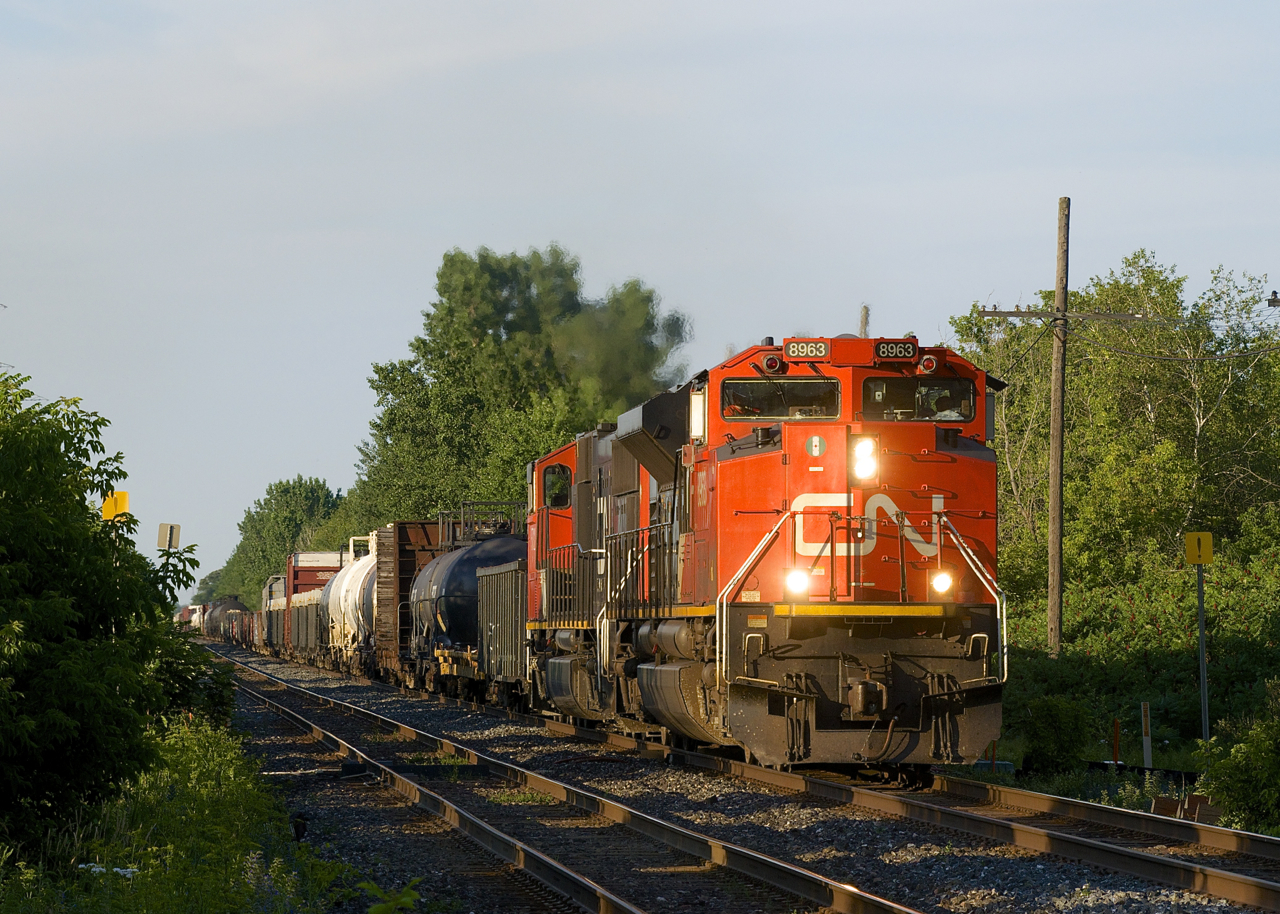 After lifting cars at Coteau, CN 321 is almost in Ontario as it passes through the small town of Rivière-Beaudette on a summer evening. Power is CN 8963 & CN 5732, an entirely decent lashup, especially by current CN standards.