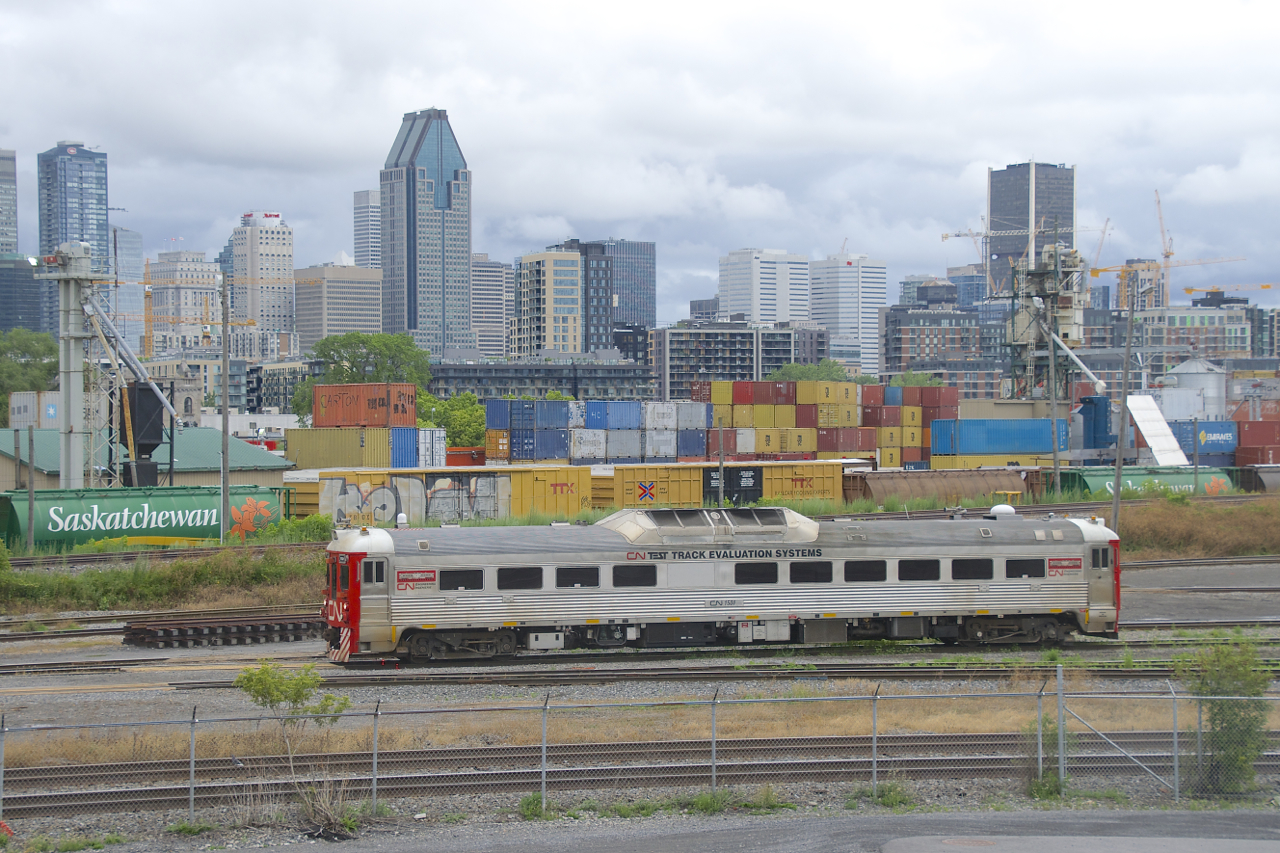 CN's test RDC is something I had been trying to shoot for years, but the timing had never worked out. This past Friday I was finally able to shoot it leaving Pointe St-Charles Yard in the morning, on its way to testing the Montreal Sub (the slightly elevated tracks in the background). Behind the Montreal Sub are some MGLX cars at Ray-Mont Logistics. Behind that is the skyline of downtown Montreal, one railway-related building is the Marriott Château Champlain hotel at left, built by CP across the street from its then headquarters of Windsor Station and opened to the public in 1967.