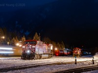 A dark, calm and quiet winter's night in downtown Revelstoke is broken by the reverberation of a westbound accelerating out of town after a crew change. In the yard a set of GE locomotives idle away, sharing company with a staged eastbound grain empty.