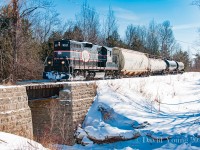 The only time to date I've capture the Barrie-Collingwood Railway running was back in February 2009 as they headed north to Collingwood to service Canadian Mist Distillers. On this bitter February day, <i>The Spirit of Collingwood</i> with a hopper for FS Partners in Stayner and three tanks for Canadian Mist in tow pictured here northbound passing over the quaint and attractive bridge over the Batteaux Creek.