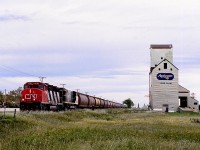 Southern Manitoba Railway Morris to Elgin grain spotter operating on former CN Miami Sub, built by Northern Pacific to reach Brandon, stops to spot elevator at Lowe Farm in the Red River Valley