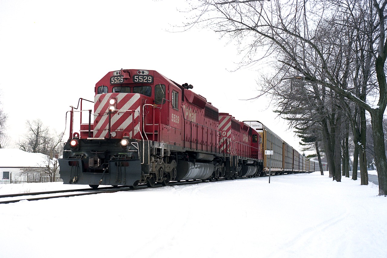 Back in the days when trains ran thru Niagara Falls downtown, we see a couple of CP SD40s hauling traffic toward the steel arch bridge to the USA.  Marker indicates ONE MILE to go. On the right is Palmer Ave. Power is CP 5529 and 5550. Track pulled around 2000.
