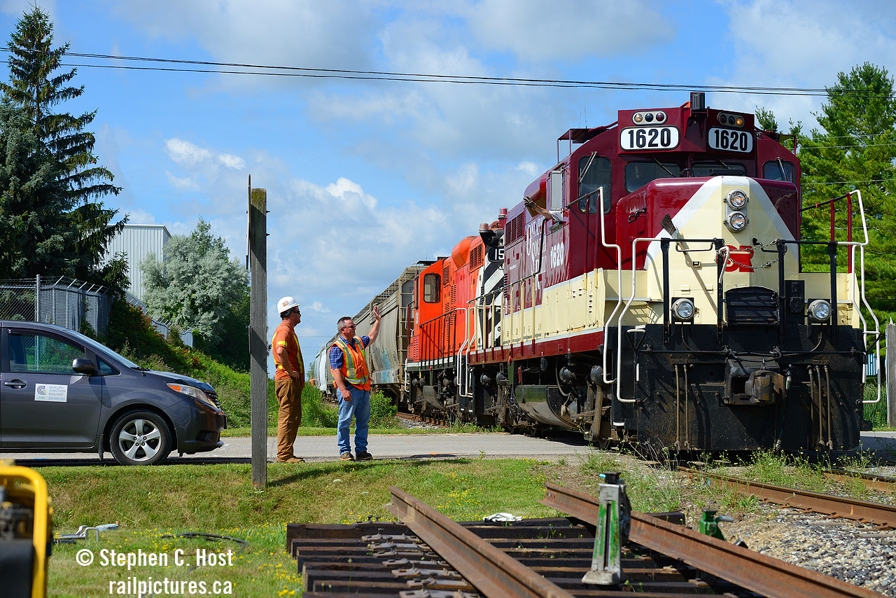 Reversing to work PDI Massey, Engr. Peter Harwick waves to Guelph Junction Railway's Les Petroczi, at the time Guelph Junction Railway's only employee complete with the GJR logo on his van. A siding was recently added at this location to assist in working AOC and PDI on this spur, and at the time, a crossing rehabilitation was planned.