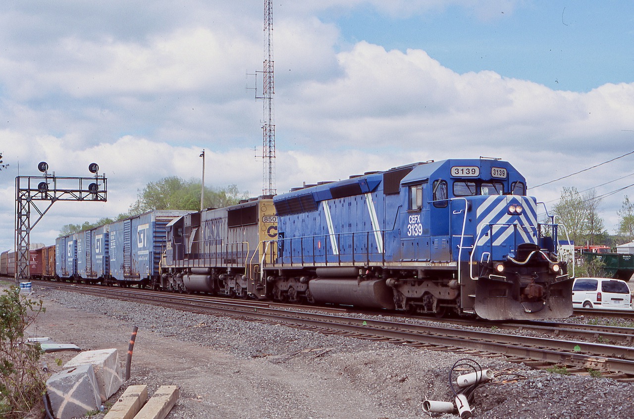 Aldershot East was I nice go to location if one missed a train working the yard, even if not all that scenic. unfortunately when the subdivision was rebuilt, the crossing at King Road was turned into a bridge. Back in 2006 it was still a level crossing and came in handy after catching CN 390 with a power set off CSX consisting of a former SP SD45 rebuilt into a SD40 for CEFX, trailing it was a CSX SD50. The power has just finished making a lift at Aldershot yard and now has a nice cut of rebuilt GT boxcars up front. The train is passing the soon to be removed signal bridge as a third main track will soon be installed in its place.