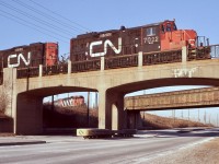 The only time I have been able to catch two CN jobs working the Ford assembly plant in Oakville. This day the job in the foreground was shuffling auto racks , while in the background another job was bringing a cut of hi-cube parts boxes back to the yard. The old bridges here cross Royal Windsor Drive and are original from when the assembly plant was built.