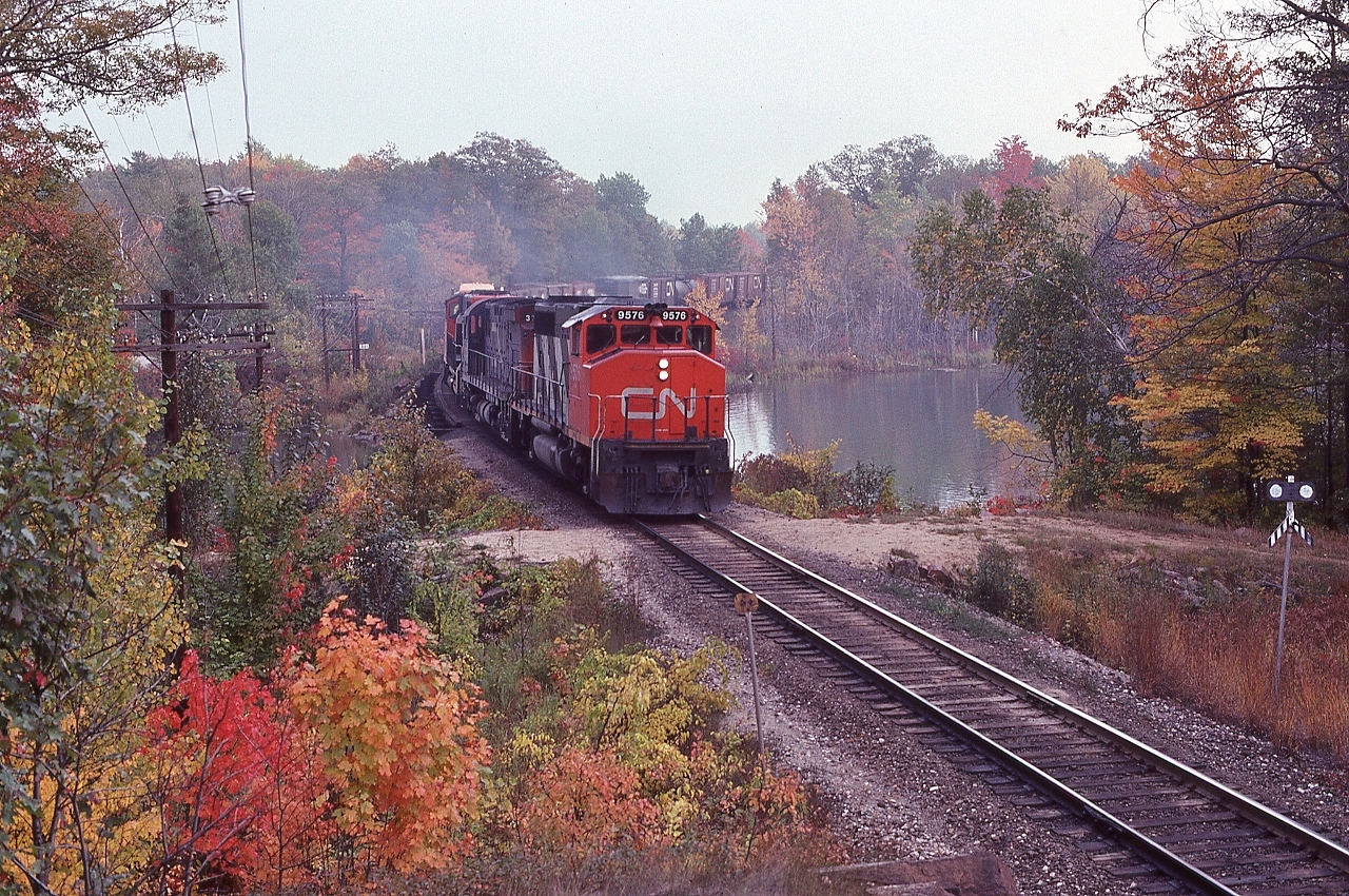 A favourite time of year.... a favourite location....


   A mixed freight with mixed power...   

 
 CN Extra 9576 North with two geeps (  GP40-2L(W)  )   and a C-424,


   GMD 1975 built # 9576  ( on roster as of 2017 )  /    MLW 1966 built # 3212  (ret by 1989)  /  95xx , 


   At mile 88.2 Bala Subdivision, September 29. 1979 Kodachrome by S.Danko


   Noteworthy: sans 'ditch lights'


   interesting: six of the final seven in the series # 9671-73; 75-77 were ex GO # 704-06;708-10)