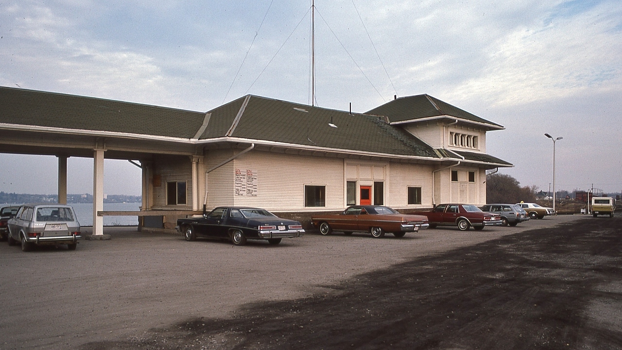 Facing south, the west side of the GTR 1905 built Allandale station.


  The fourth station to stand on this site, the first built circa 1953 by the broad gauge Ontario, Simcoe & Huron Railroad ( reorganized 1858 to become the Northern Railway of Canada ( converted to standard gauge 1881) and absorbed into the GTR 1888 ) 


  At Allandale, November 18, 1978 Kodachrome by S.Danko


  More Allandale ( aka Barrie ): 


       east side sight 


   Interesting:


    From the left (clarifications welcomed ):  Kempenfeldt Bay is visible through the covered breezeway and the vehicles: a VW  ( Passat ?) wagon ; 197x Buick Le Sabre; 196x  Plymouth Fury; 1978 Chevrolet Caprice; seventies Datsun ( today it's Nissan) wagon; 197x Dodge Monaco or Plymouth taxi; seventies Ford pickup with cap; 


   and in the far distance in the Allandale yard, CN power beside the GTR 1903 built Master Mechanic and Stores Department building ( the turntable was located next to the Mechanic's building)


   To the right of the photographer is the connecting track to the CN Meaford Subdivision ( railway crossing at grade mile 7.5 with CP Rail Mactier Sub) 


   More:


   The CN Office Signals for  CN  Barrie is  ' G O  '


   sdfourty