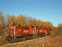 A maze of branch lines operated out of Prince Albert, with CP often utilizing CN lines to access CP branches.  One was the Nipawin Turn for 18 miles on the CN Paddockwood sub. to a junction at Sharpe with the CP White Fox sub. eastward to Nipawin.  Typical service was a pair of MLW RS-23s and a caboose on CN from Prince Albert to Sharpe then on CP to Meath Park, then picking up grain loads through to Nipawin, then empties westward with setoffs at active grain elevators up to Meath Park, then running cab hop home to Prince Albert.  On Tuesday 1976-09-28, that is what 8015 and 8017 are doing, westbound at Gobeil Road and less than a mile from CN track at Sharpe.

<p>Today, this is empty grade; track extends northward from Prince Albert only 8 miles to White Star (Carleton Trail) and westward from Nipawin to Choiceland (Torch River Rail).</p>
