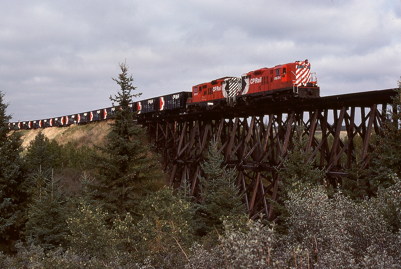 West of Stettler and east of Lacombe on the aptly named Lacombe subdivision, CP used to cross Tail Creek at mileage 74.3 between Nevis and Macbeth on a straight timber trestle bridge of significant proportions, later bypassed to the north by a curved fill with a culvert.  On Thursday 1978-09-14 at 1021 MDT, that bridge was traversed by an eastward ballast work train with GP9s 8834 and 8662 for power.