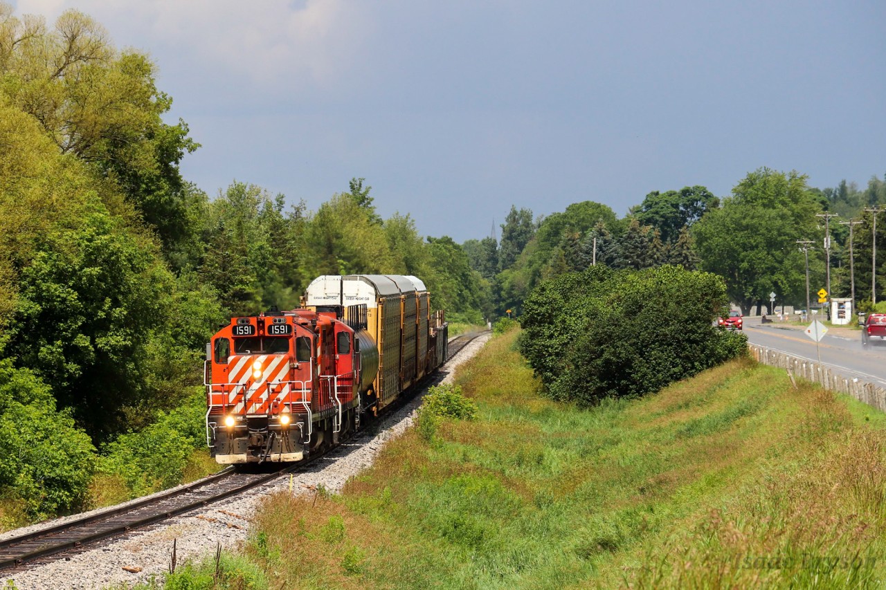 OSR 1591 (GP9u) and OSR 8235 (GP9u) run parallel to Beachville Rd. as they pull 7 cars back towards Ingersoll. As both GP9us are Ex CP and the track used to be operated be Canadian Pacific, this scene is a modern day replica of scenes from the past. To top it all off, the OSR train had to wait for a CN at Carew for about 25 minutes. In that time, a short thunderstorm passed and just as the T-storm cleared, the OSR appeared in perfect storm light.