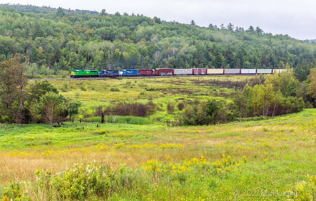 NBSR 6401 powers train 907 through the fields at Clarendon, New Brunswick.